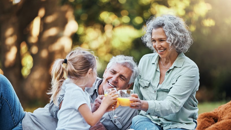 brightly-health-coaching-juice-vitamin-c-family-picnic-with-child-grandparents-healthy-growth-development-outdoor-wellness-lifestyle-senior-grandmother-elderly-people-girl-with-orange-drink-bokeh-park