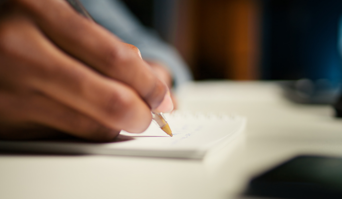 Brightly-Biomarkers-black-freelancer-researching-online-data-writing-notes-articles